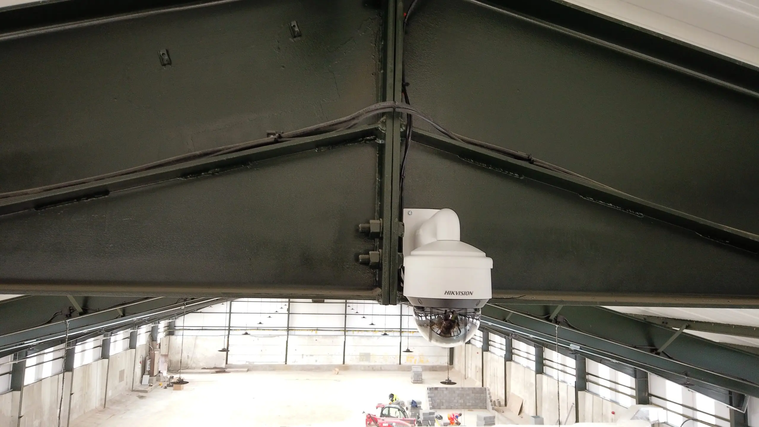 Security camera installed on a steel beam inside a warehouse—project by Rajvar.