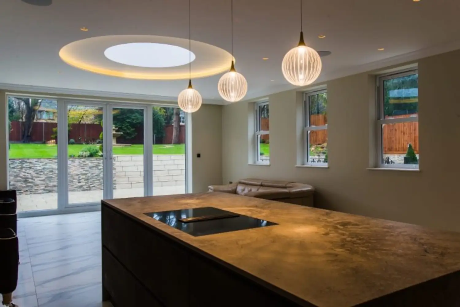 Modern open-plan kitchen featuring a circular ceiling light, marble flooring, beige designed by Rajvar Technologies.