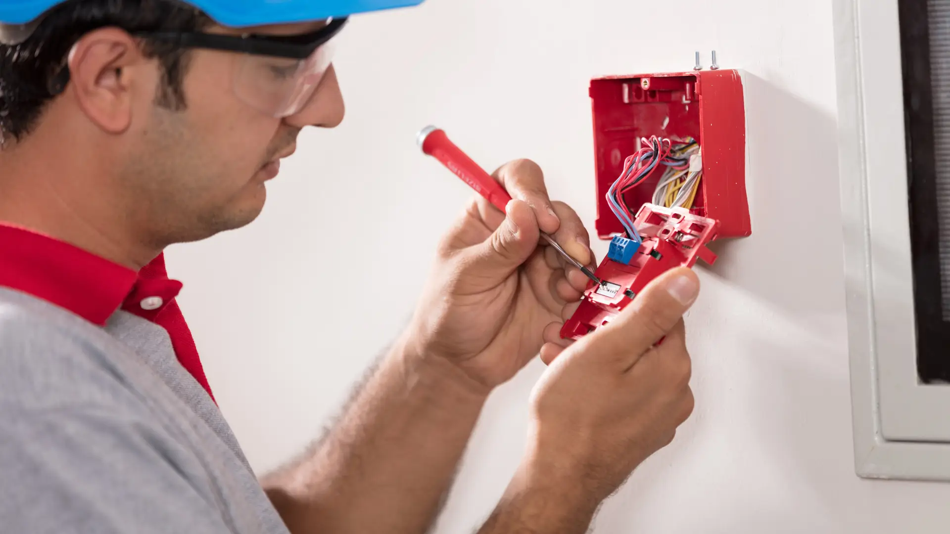 Technician installing or repairing a fire alarm system, working with internal wiring-project by Rajvar.